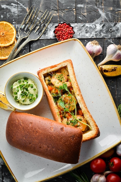 Baked seafood with vegetables in bread Shrimp mussels squid Top view Free space for text