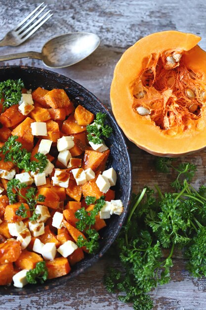 Baked slices of pumpkin with slices of white cheese.