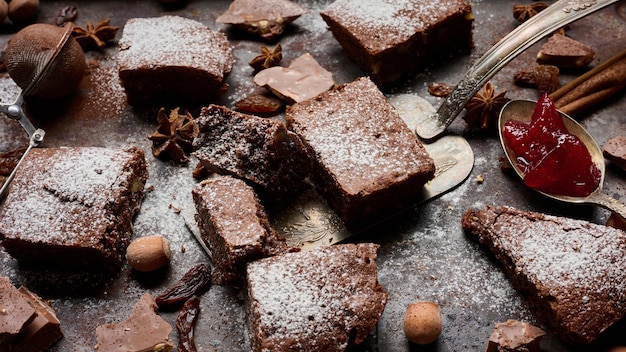 Baked square pieces of chocolate brownie sprinkled with powdered sugar on the table top view