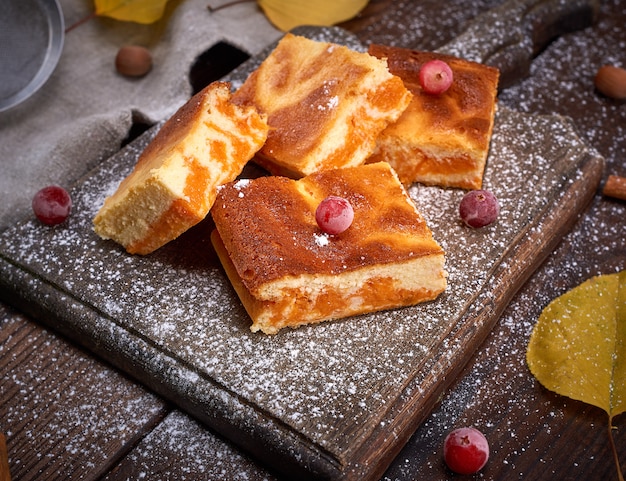 Baked square pieces of pumpkin cheesecake