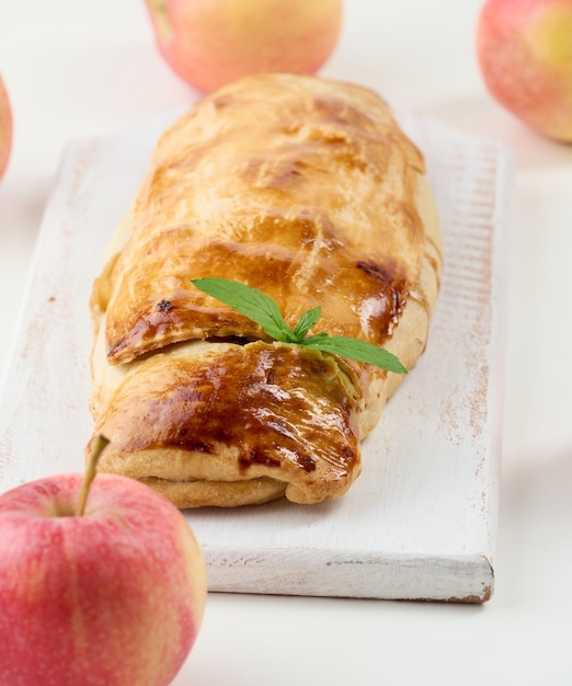 Baked strudel with apples on a white wooden board delicious dessert