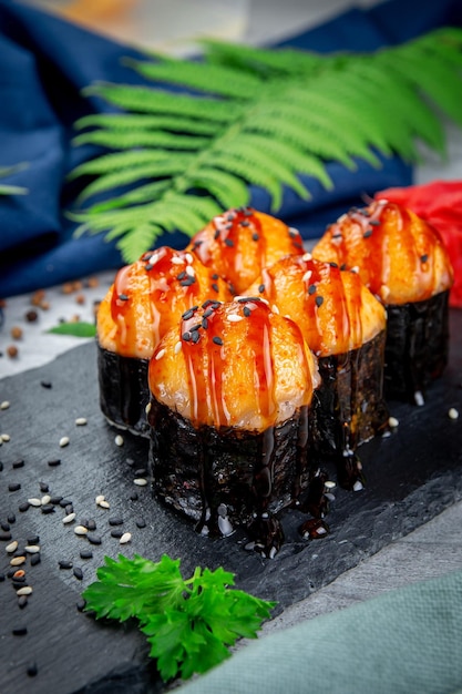 Baked sushi rolls with ayashi cap of crab sauce and unagi sauce Traditional Japanese Cuisine