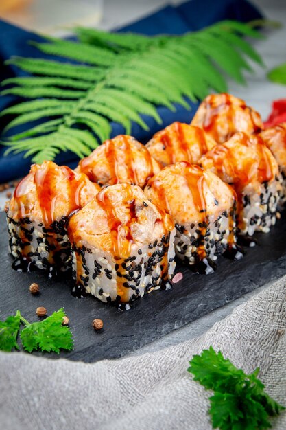 Baked sushi rolls with sesame and salmon cream cheese Traditional Japanese cuisine