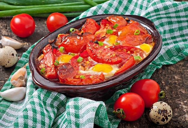 Baked tomatoes with garlic and eggs decorated with green onions