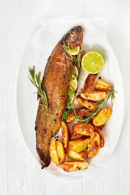 Baked trout fish with roast potatoes top view