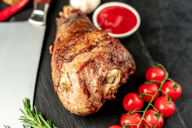 Baked turkey turkey leg with rosemary on a stone table