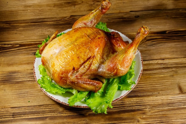 Baked whole chicken on a wooden table