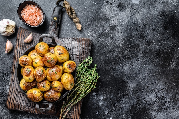 Baked youg potato with thyme in a pan