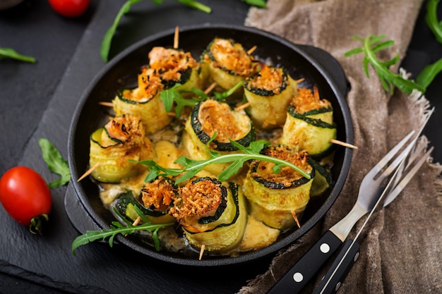 Baked zucchini rolls with cheese, carrot and chicken breast