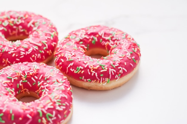 Bakery branding and cafe concept  frosted sprinkled donuts sweet pastry dessert on marble table background doughnuts as tasty snack top view food brand flat lay for blog menu or cookbook design