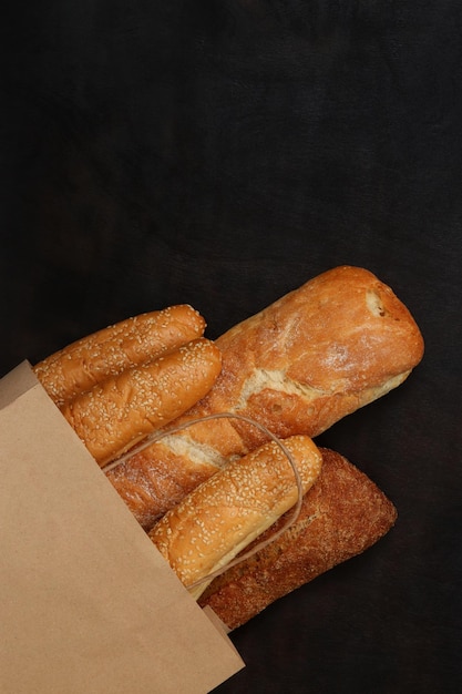 Bakery products in a paper bag Sale of pastries fresh bread Baguettes sesame buns and a loaf