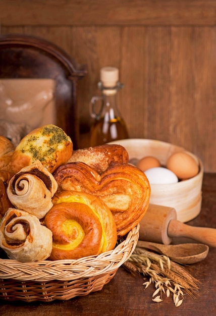 Bakery products of various types Wicker basket with different types of bread on a wooden table