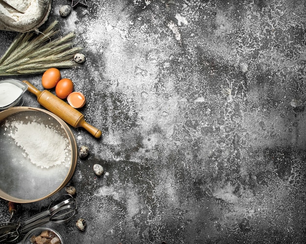 Baking background. Ingredients and tools for dough preparation. On a rustic background.