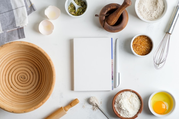 Baking ingredients for cooking homemade traditional bread with paper for recipe on a light grey marble table.