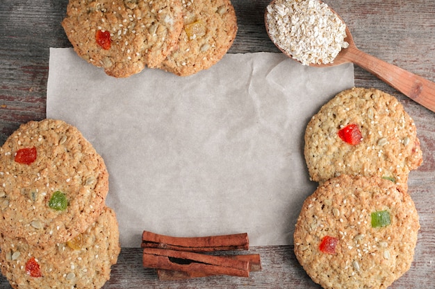 Baking, oat biscuits in a flatlay with a wooden spoon and cinnamon sticks on baking paper 