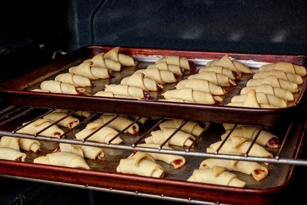 Baking rolled up croissant cookies stuffed with marmalade.