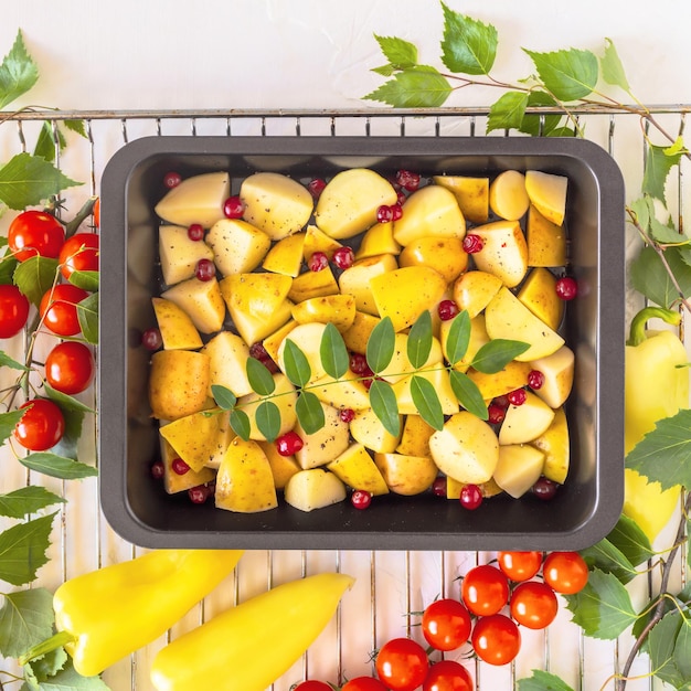 Baking tray with farm new crop potatoes berries and seasonal vegetables