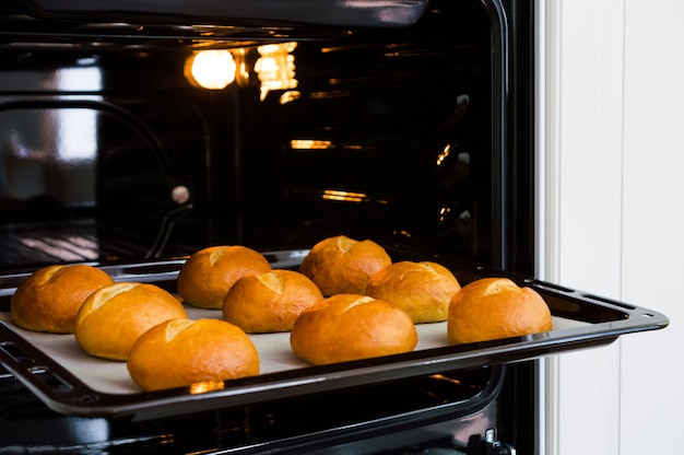 Baking tray with fresh homemade buns in the oven.