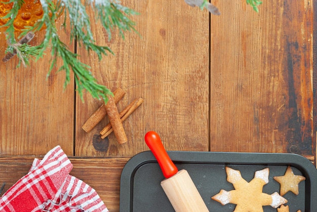 A baking tray with a rolling pin and a red and white plaid towel on the side