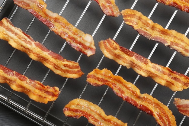 Baking tray with strips of fried bacon closeup