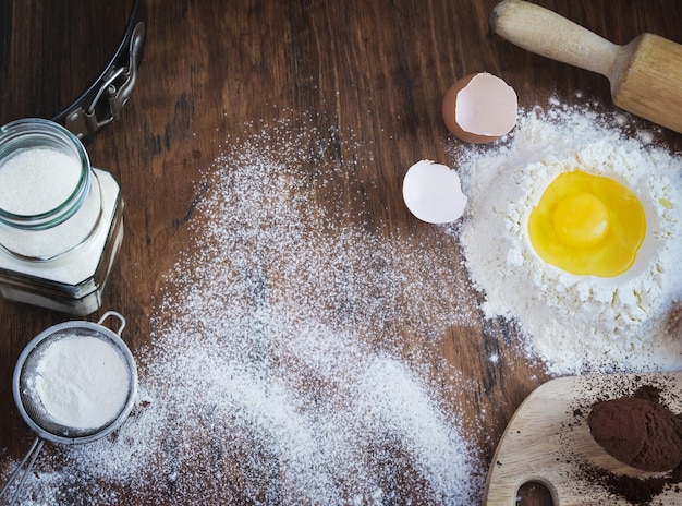 Baking  vintage background with raw egg, flour, sugar and cocoa