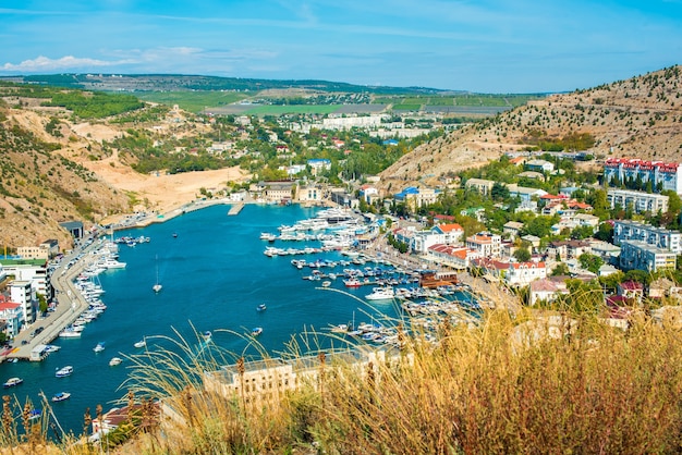 Balaklava bay in summer in sunny weather. Crimea, Russia. A lot of boats and ships. mountains, sea. turquoise water color. Genoese fortress Chembalo