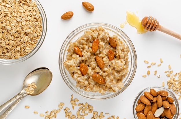 Balanced diet food menu for breakfast with oats porridge bowl with almonds and honey