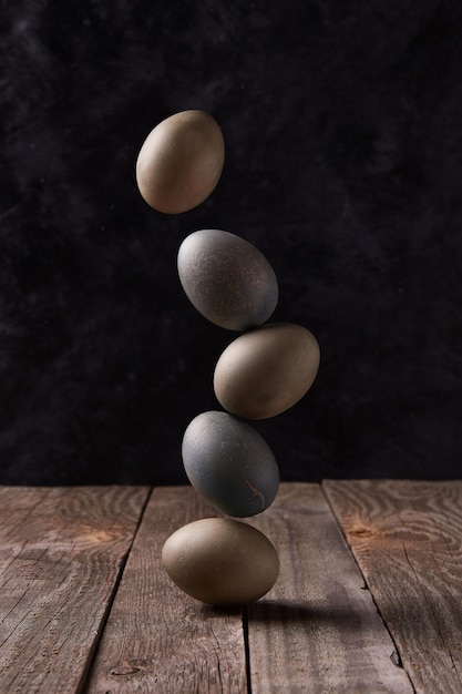 Balancing dyed eggs on wooden table easter celebration concept