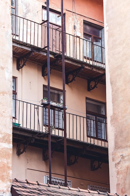 Balconies and iron staircase of old building Old architecture