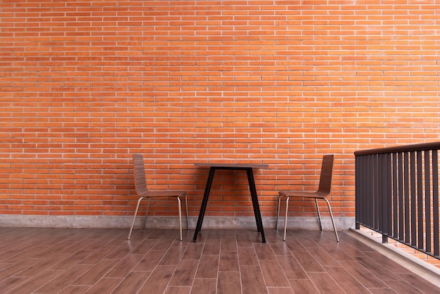 Balcony with red brick wall and table chairs set