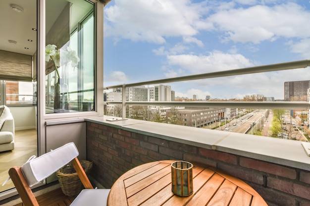 a balcony with a table and chairs looking out at the city from it's roof top deck which is covered in white