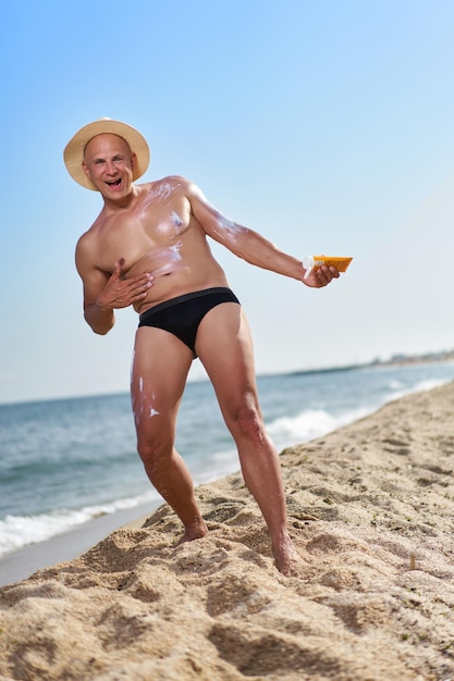 Bald man on the beach by the sea on vacation