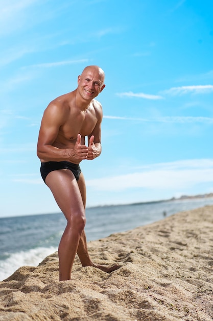 Bald man on the beach by the sea on vacation