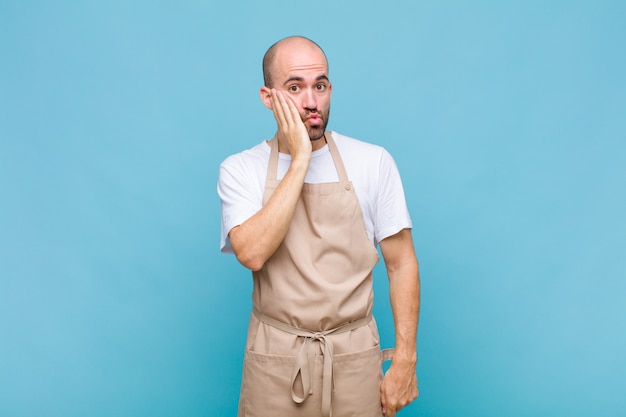 Bald man feeling shocked and astonished