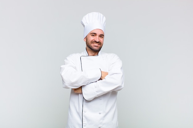 Bald man looking like a happy, proud and satisfied achiever smiling with arms crossed