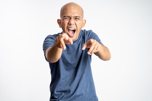 Bald man opens mouth wide while laughing with fingers pointing