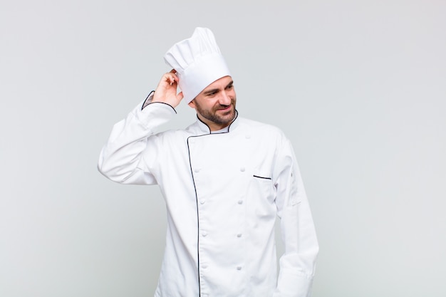 Bald man smiling cheerfully and casually, taking hand to head with a positive, happy and confident look