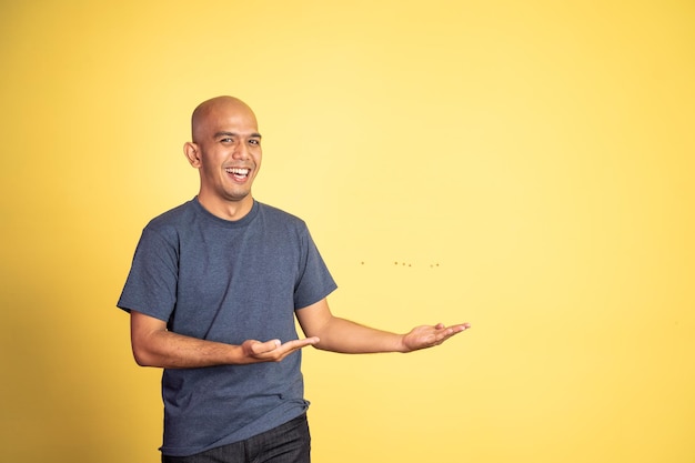 Bald man smiling with both hands presenting something