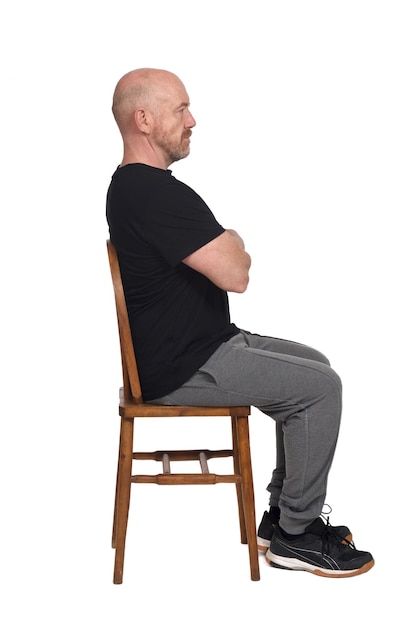 Bald man with sportswear sitting on white background