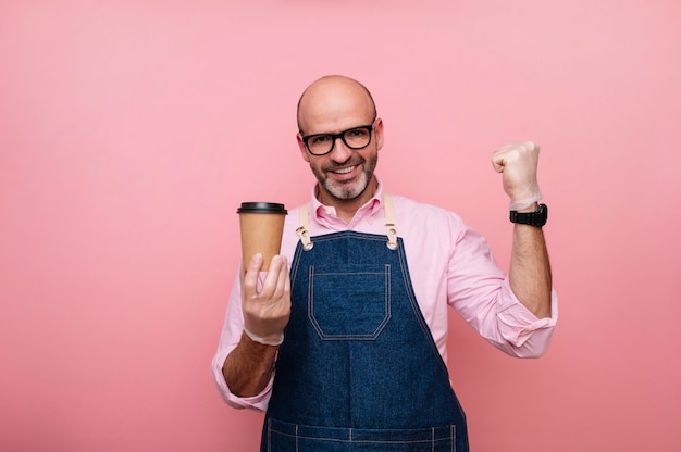 Bald mature man euphoric with happiness with coffee in recyclable cardboard cup