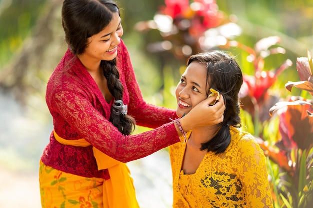 Balinese girl traditional dress decorates a girl with a flower