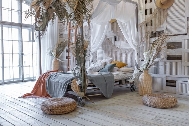 Balinese style bedroom interior. canopy bed with lots of textiles for decoration and wicker items in soft pastel colors