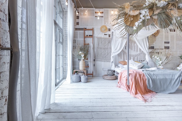 Balinese style bedroom interior. canopy bed with lots of textiles for decoration and wicker items in soft pastel colors