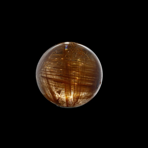 Ball of quartz with rutile on a black background closeup