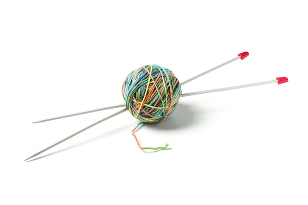 Ball with multicolored woolen threads and knittings stuck into it