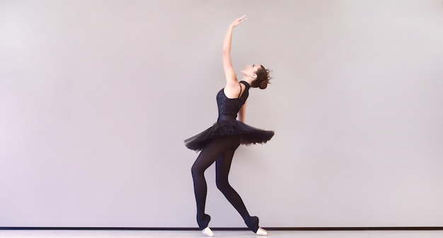 Ballerina in black swan dress Young ballet dancer practicing before performance in black tutu classical dance studio copy space