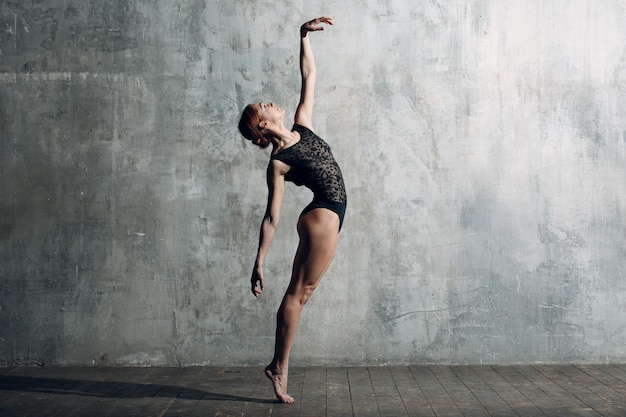 Ballerina female. Young beautiful woman ballet dancer, dressed in professional outfit, pointe shoes and black body.