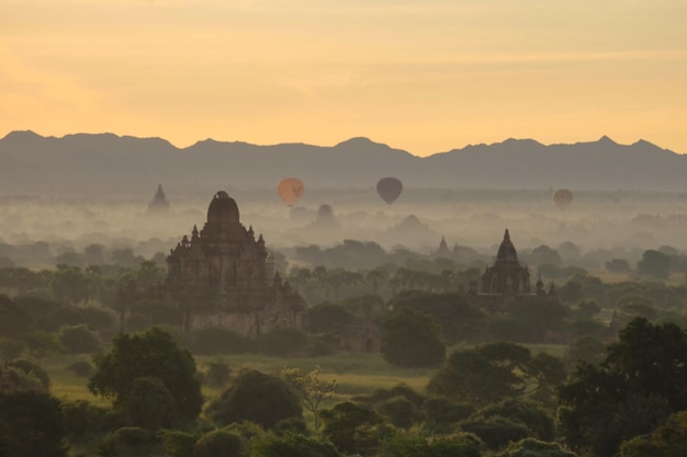 Balloons flew over the pagodas in the mist of morning at Bagan