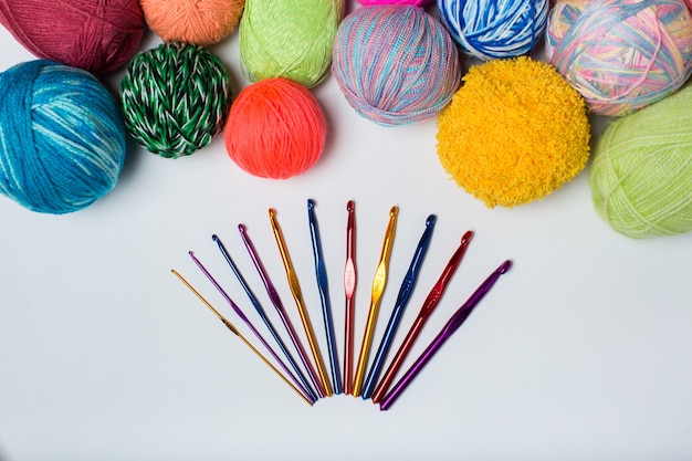 Balls of colored yarn of the rainbow sample knit crochet and knitting needles