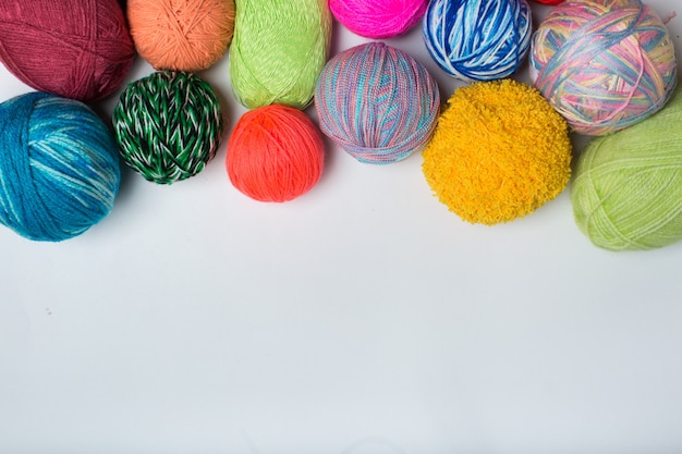 Balls of colored yarn. View from above. All the colors of the rainbow. Sample knit. Crochet.